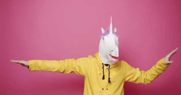 Chico feliz con ropa amarilla Baile con máscara de unicornio. Día de los tontos y abril 1 día. — Vídeo de stock