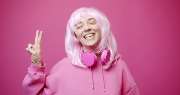 Lykkelig ung kvinde 20 'erne år gammel bærer lyserød t-shirt viser sejr tegn – Stock-video