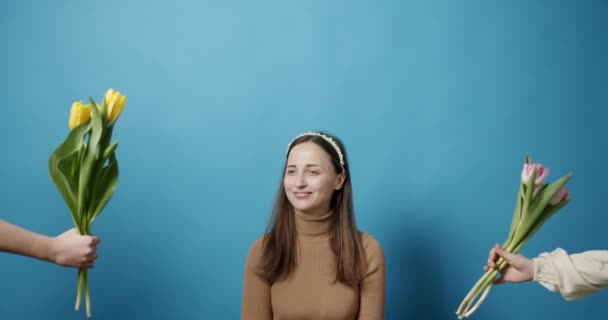 Irmãs com tulipas flores dando à mãe em um fundo azul, Mãe feliz. — Vídeo de Stock