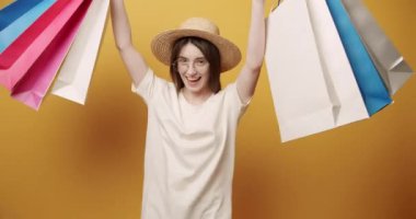 Şapkalı ve gözlüklü güzel kadın mutlu. Alışveriş 'ten geliyor.