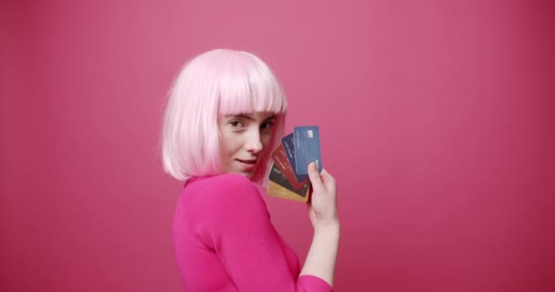 Schoonheidsvrouw met roze wit haar en roze kleren. toon in haar hand credit card — Stockvideo