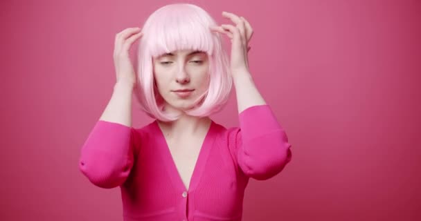 美しい目、ピンクの白い髪とピンクの服を持つ美しさの女性は髪をアレンジ — ストック動画