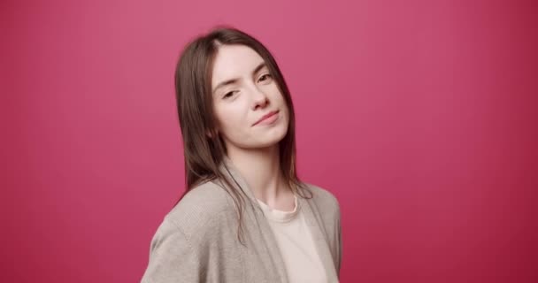 Красота привлекательная женщина с красивыми глазами, укладывает волосы на розовом фоне — стоковое видео
