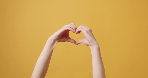 Gadis cantik membuat hati dengan tangannya dalam bentuk hati. Konsep cinta. — Stok Video