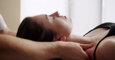 Profesyonel bir masör, sakin bir kadına kafa ve boyun tedavisi uygular. 