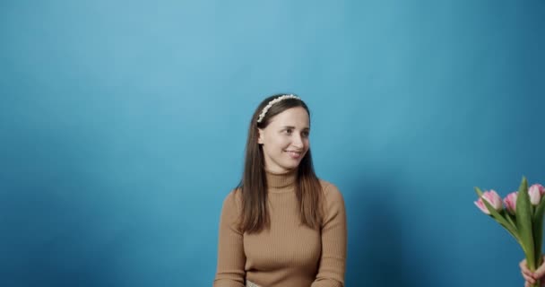 Hermanas con tulipanes flores dando a mamá sobre un fondo azul, Madre feliz. — Vídeos de Stock