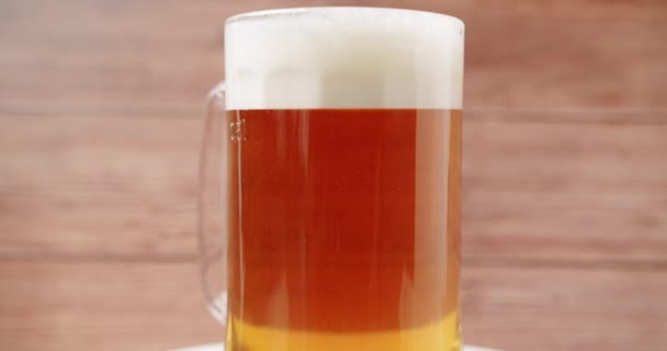 Plné pivo do velkého skla, Pivní hrnek na dřevěném pozadí. — Stock video