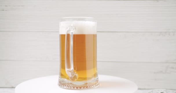Разлить пиво в большой стакан, кружку пива на белом фоне. — стоковое видео