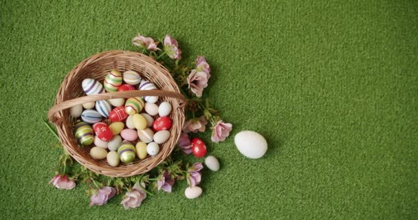 Cesto con molte uova colorate su sfondo erba verde.Banner per messaggio di testo — Video Stock