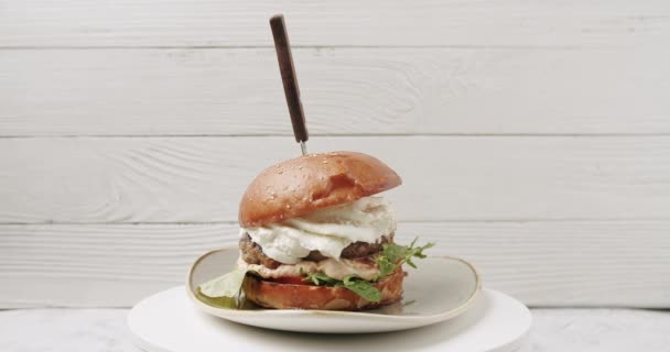 Δροσερό όμορφο φρέσκο ζουμερό μαγειρεμένο burger περιστρέφεται σε πικάπ σε λευκό φόντο — Αρχείο Βίντεο