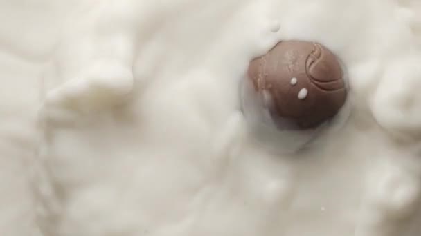 丸いチョコレートは溶かしたヨーグルトに落ち、クラウンと円形のリップルを作る — ストック動画