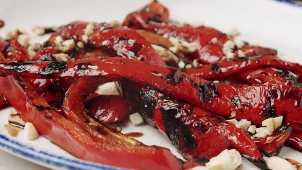 Grillad röd paprika. läckra grönsaker med nötter på en roterande vit tallrik — Stockvideo