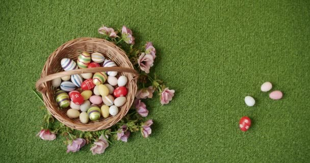 Кошик з багатьма кольоровими яйцями на фоні зеленої трави. Банер для текстового повідомлення — стокове відео