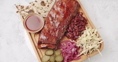 İçinde kirazlı chipotle soslu bebek kaburgaları olan büyük bir tabak.
