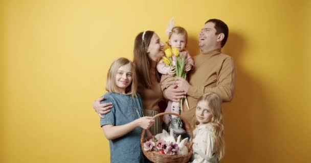 Lycklig familj som har roligt och poserar med blommor och kanin, påskdagen. — Stockvideo