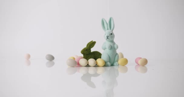 Kaniner leksaker på vit bakgrund, många ägg. Grattis på påskdagen. Textmeddelande — Stockvideo