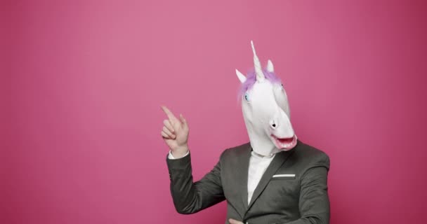 Glad kille i grå kostymer han har kul med Unicorn Mask. Dårarnas dag — Stockvideo
