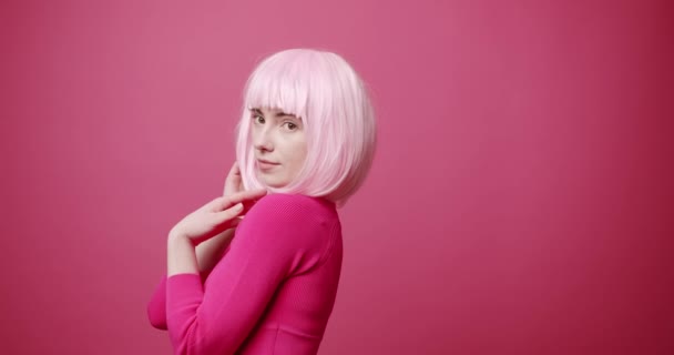 美しい目、ピンクの白い髪とピンクの服を持つ美しさの女性は髪をアレンジ — ストック動画