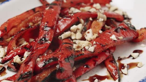 Grillad röd paprika. läckra grönsaker med nötter på en roterande vit tallrik — Stockvideo