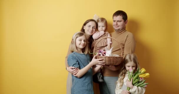 Mor far och barn kramar, har roligt och poserar på gul bakgrund — Stockvideo