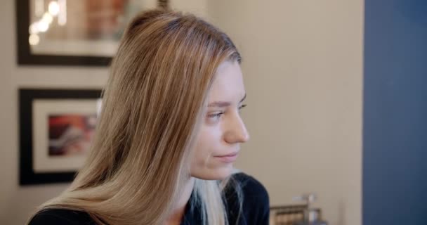 Hermosa mujer pensante mirando alrededor en un café. Está esperando. Esperando. — Vídeos de Stock