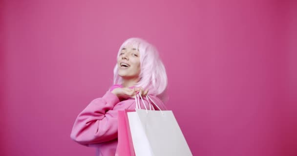 Mutlu kız pembe renkli çantalarla alışverişin tadını çıkarıyor. — Stok video