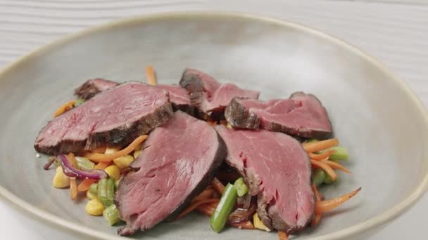 Салат из овощей на гриле с редкой говядиной в белой тарелке. — стоковое видео