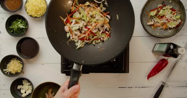 Chef-kok Holding koekenpan en Vallende Wok Noodles met veel verschillende groenten — Stockvideo