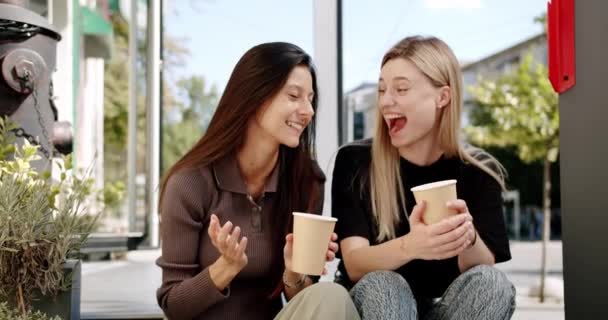 Twee vrienden genieten van een gesprek met thee- en koffieglazen, verliefd buiten — Stockvideo