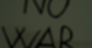 Elinde savaş yok mesajı olan beyaz bir kağıt tutan kişi. Savaş Mesajı İstemiyoruz.