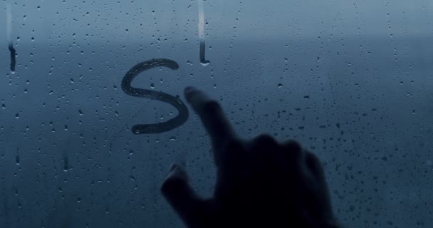 En mans hand skriver ett Stop War-meddelande på fönstret med fingret. — Stockvideo