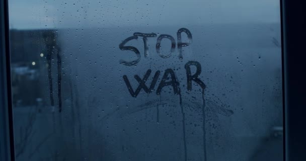 Text Stop the War skriven på ångande fönster på en suddig bakgrund. — Stockvideo