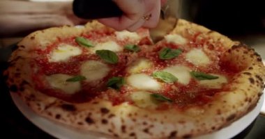 Yuvarlak bir bıçakla pizza kesmek. Yakın plan Lezzetli Pizza Margherita.