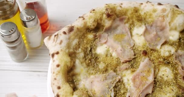 Pizza med kött, Pesto, ost och parmesan färskt ur ugnen redo att äta. — Stockvideo