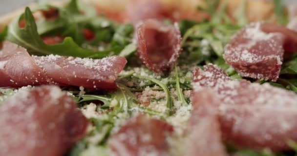 Close Up Pizza with prosciutto parma ham, arugula salad rocket with ingredients — Stock Video