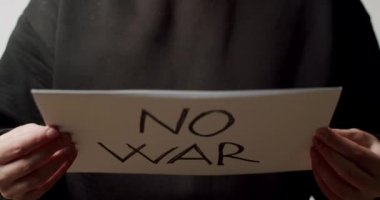 Elinde savaş yok mesajı olan beyaz bir kağıt tutan kişi. Savaş Mesajı İstemiyoruz.