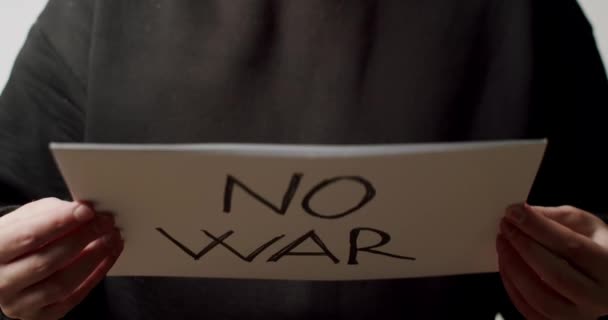 Person som håller i en vitbok med ett meddelande "Inget krig". Vi vill inte ha något krigsmeddelande. — Stockvideo