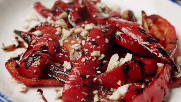 Pimientos rojos a la plancha. deliciosas verduras con nueces en un plato blanco giratorio — Vídeos de Stock