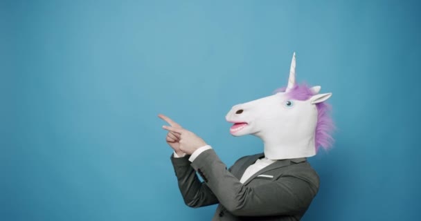 Día de los tontos. Hombre feliz con máscara de unicornio. satisfecho y muestra el signo similar. — Vídeo de stock