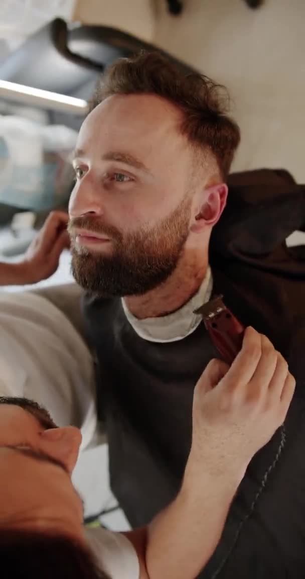 Homem bonito recebendo novo penteado com aparador elétrico. Barbeiro moderno. — Vídeo de Stock