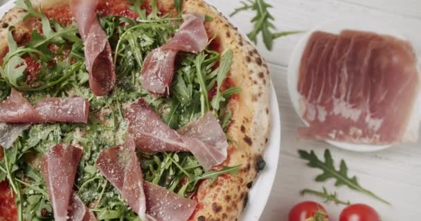 Delicious Pizza με prosciutto parma ham, ρόκα σαλάτα ρόκα ρόκα ρόκα με συστατικά — Αρχείο Βίντεο