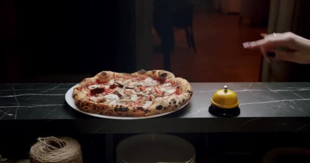 Heerlijke pizza is klaar om opgediend te worden. Een vrouwenhand drukt op Bell Button. — Stockvideo