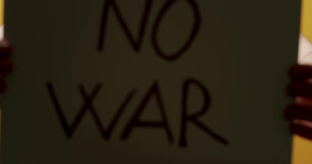 Elinde "Savaşı durdurun" mesajı olan beyaz bir kağıt tutan kişi. Savaş Mesajı İstemiyoruz. — Stok video