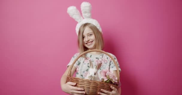Söta flickor med kaninöron leker med kaninen på en isolerad bakgrund — Stockvideo