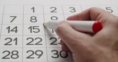 Mans el Kağıt takvimine kırmızı bir kalem kullanarak 23üncü günü yaz.