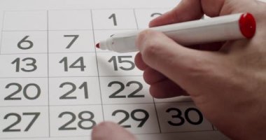 Mans el Kağıt takvimine kırmızı bir kalem kullanarak 23üncü günü yaz.