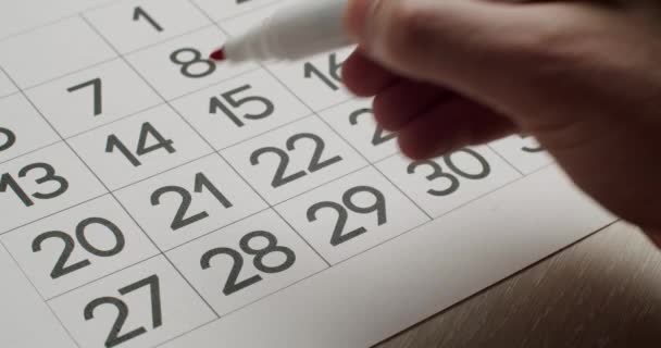 Mans hand Schrijf de 21e dag op de papieren kalender op met een rode pen. — Stockvideo