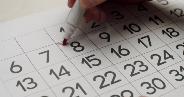 Mans hand Schrijf de 23e dag op de papieren kalender op met een rode pen. — Stockvideo