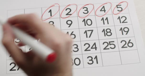 Mans hand Schrijf de 6,7,8,9,10,11,12 dag op kalender op met een rode pen. — Stockvideo