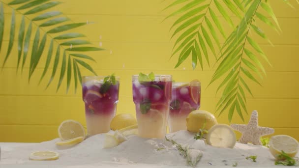 Letní koktejl Sklenice limonády, máta a kostky ledu na žlutém pozadí. — Stock video